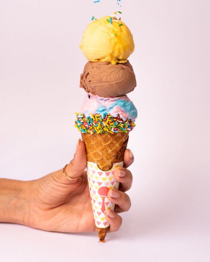 An ice cream cone stacked with three scoops.