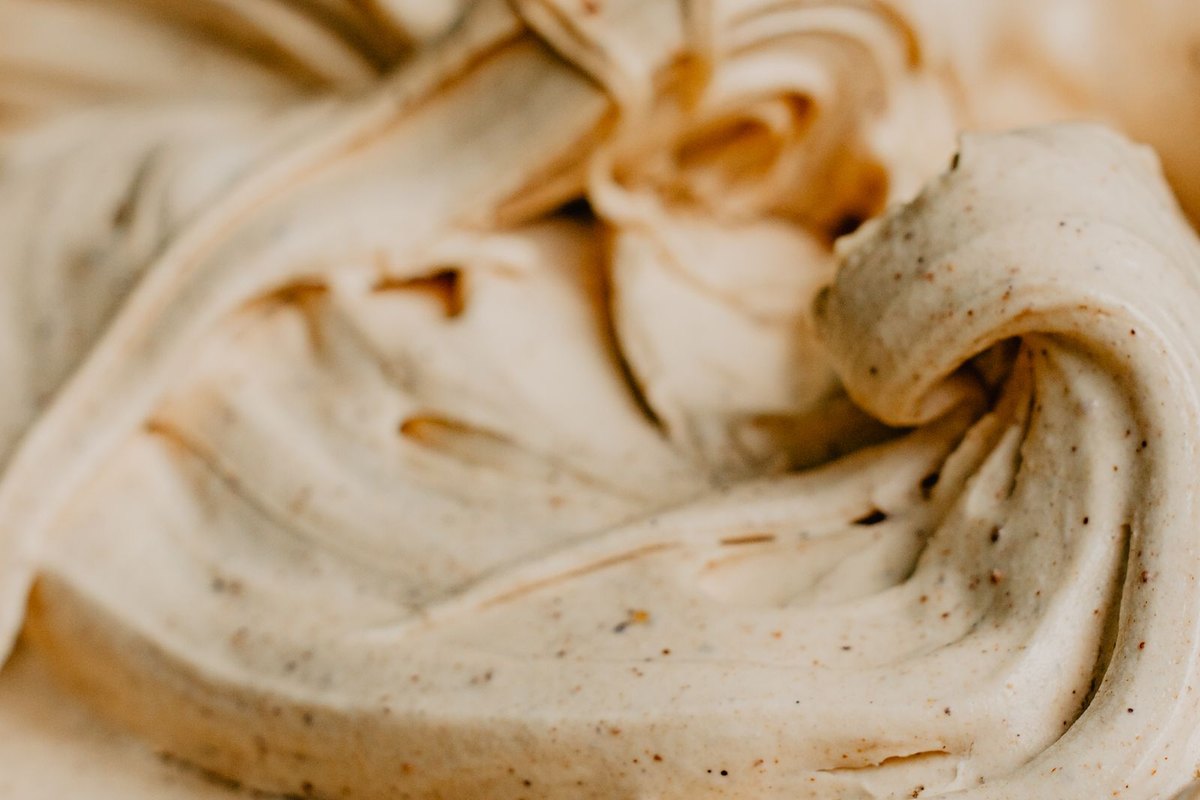 Close view of softly swirled ice cream, pale cream and caramel.